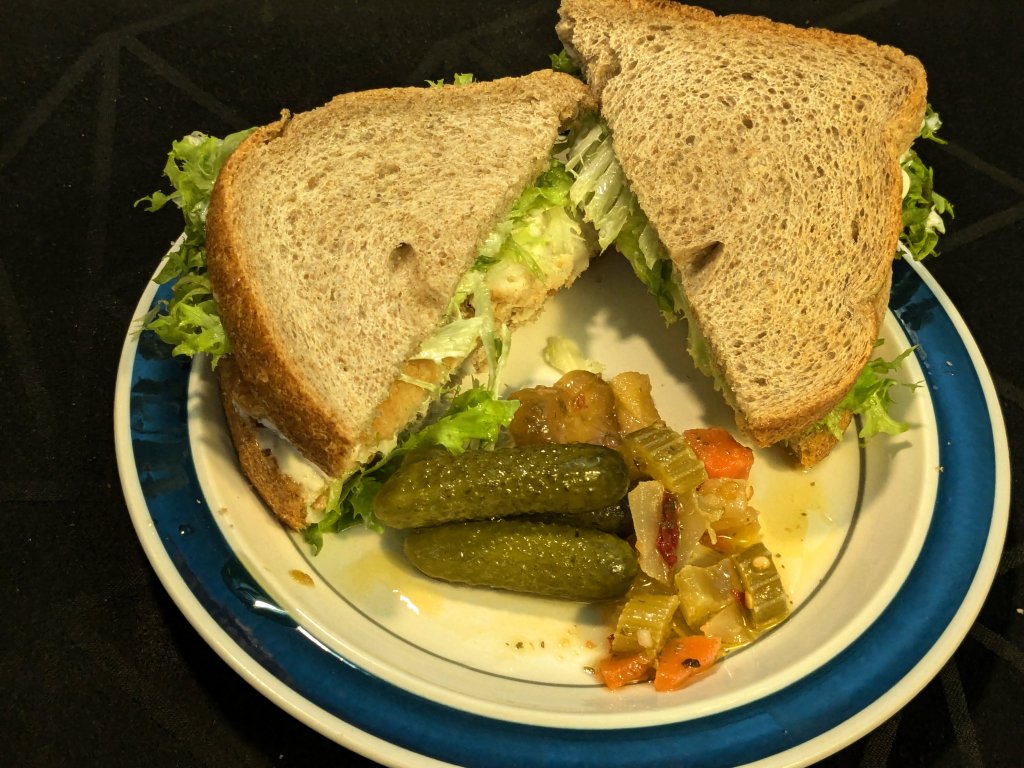 2024-10-10 Sandwich of whole wheat toast with breaded haddock, lettuce, and mayo with gherkins...jpg