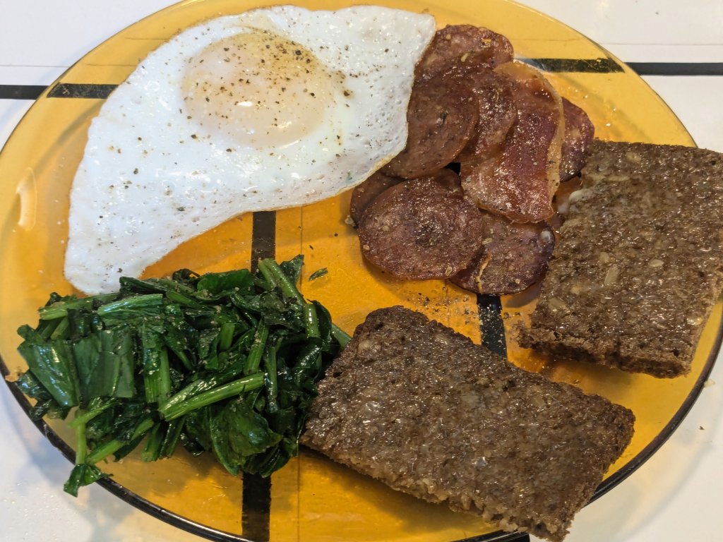 Breakfast for supper - duck egg, fried charcuterie, sautéed spinach, and toasted rugbrød.jpg
