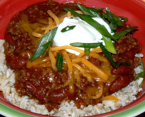 Spicy chili  over brown rice topped with cheddar, sour cream and green onions.